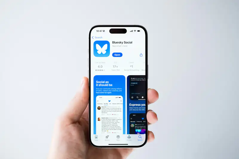 Mano sosteniendo un iPhone con una aplicación móvil abierta