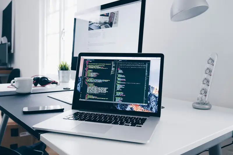 Laptop con el código de una página web abierta sobre un escritorio de trabajo